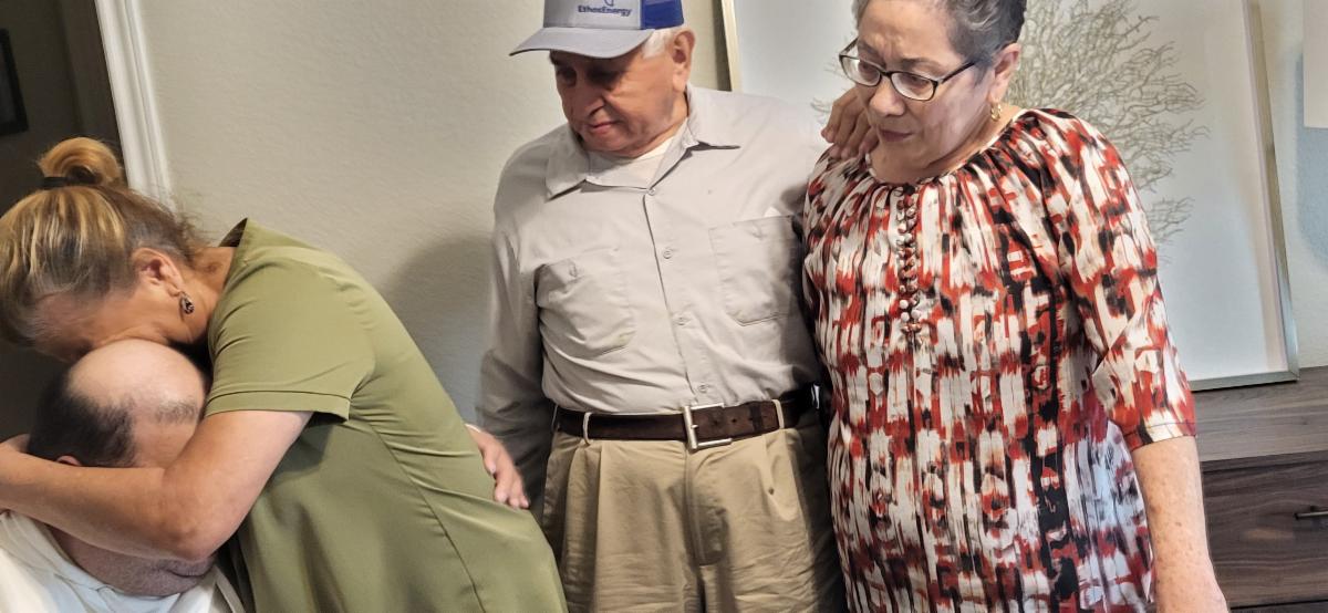 Overwhelmed with joy, Mrs. Batres and her son embrace tightly, surrounded by family, immediately following the reveal of their newly transformed room